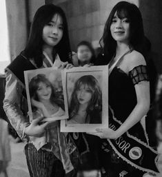 two beautiful women holding up pictures in front of them