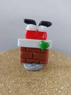 there is a small toy made to look like santa on top of a brick wall