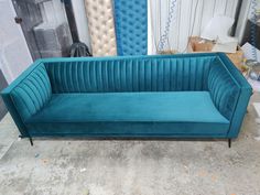 a blue couch sitting on top of a cement floor