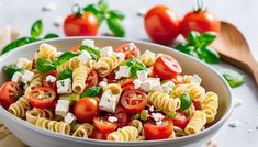 a white bowl filled with pasta and tomatoes