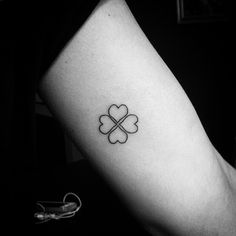 a four leaf clover tattoo on the arm