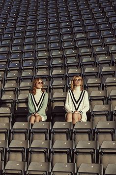 two women sitting in the stands at a baseball game