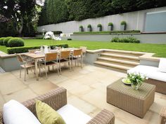 an outdoor dining area with chairs, tables and stairs leading up to the back yard