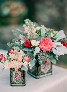 two vases with flowers are sitting on a table