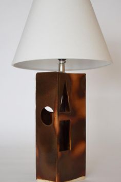 a lamp that has a bird house on it with a white shade over the top