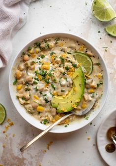 a white bowl filled with soup and topped with an avocado