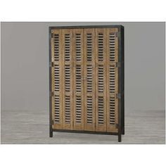 an old wooden cabinet with shutters on the front and side doors, sitting on a wood floor