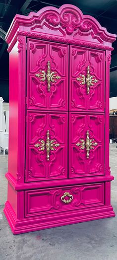 a pink armoire with ornate carvings on the front and sides, painted bright pink