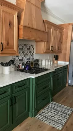 a kitchen with green cabinets and white counter tops