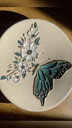 a blue and white butterfly sitting on top of a wooden table