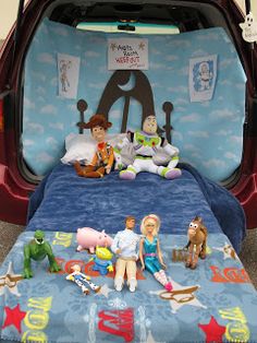 there are many toy characters sitting on the bed in this car trunk, and it's been made to look like disney pixama