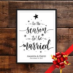 this is the season to be married sign with red ribbon and bow on wooden background