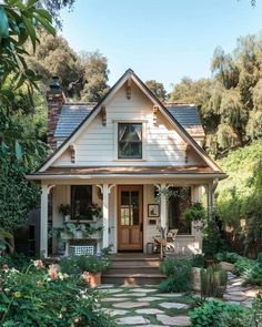 a white house surrounded by greenery and flowers in the front yard, with a stone walkway leading to the front door