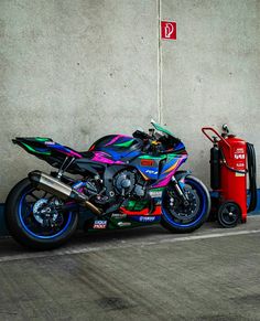 a colorful motorcycle parked next to a wall