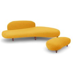 an orange couch and footstool sitting next to each other on a white background