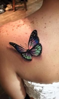 a woman's chest with a butterfly tattoo on it