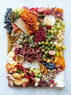 an art work made out of various fruits and veggies on a white surface