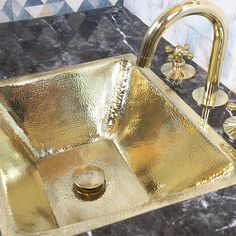 a gold sink in a bathroom next to a faucet