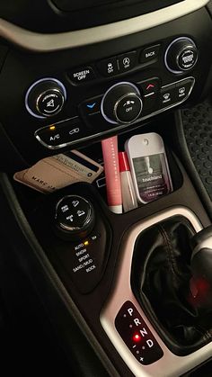 the interior of a car with various items in it's center console and control buttons