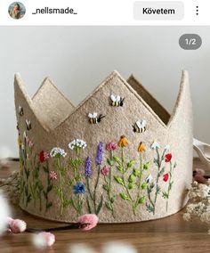 a crown made out of felt with flowers and bees painted on it's sides