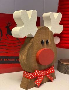 a wooden reindeer with red nose and polka dot bow