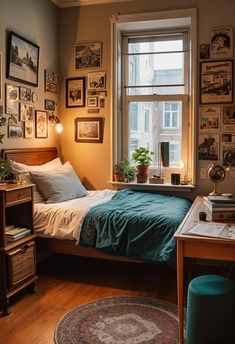 a bed sitting in a bedroom next to a window with pictures on the wall above it