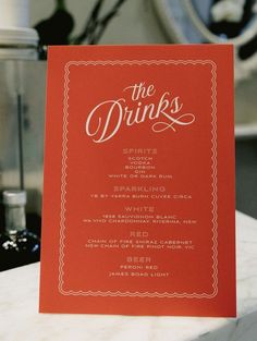 Orange bar menu titled "The Drinks" for wedding and events.