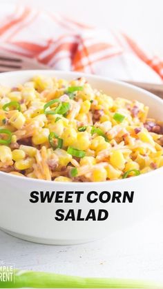 a white bowl filled with corn salad next to green onions and celery sticks