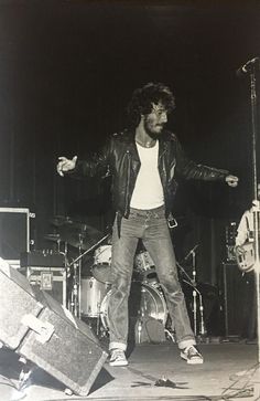 a man standing on top of a stage with his arms out in front of him