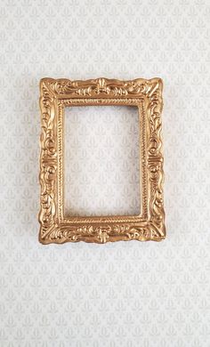 an ornate gold frame on a white wall