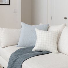 a white couch with several pillows on it