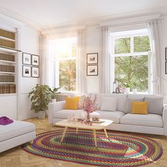 a living room with white couches and colorful rugs on the wooden flooring