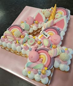 a pink cake with unicorns and other decorations on it