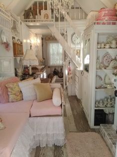 a living room filled with furniture and a chandelier hanging from the ceiling above it