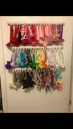 a bunch of different colored bows hanging on a wall