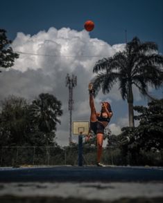 a woman is jumping up to catch a basketball in the air with her right hand