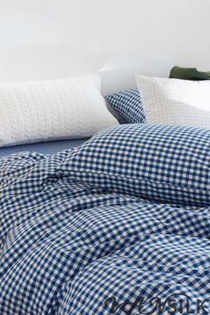 a blue and white checkered comforter set on a bed with two pillow cases