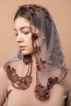 a woman wearing a veil with flowers on it