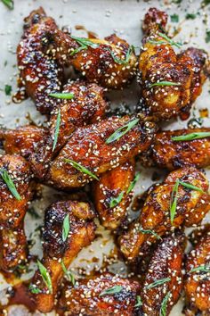 chicken wings covered in sesame seeds and garnished with herbs