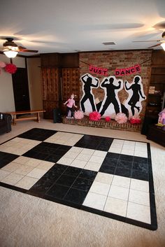 the dance floor is decorated with black and white tiles, pink pom poms, and paper flowers