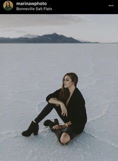 a woman sitting in the snow with her legs crossed