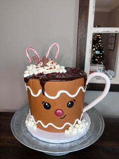 a cake decorated like a cup with candy and candies on top, sitting on a plate