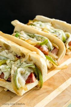 three tacos sitting on top of a cutting board