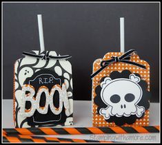 two halloween treat boxes decorated with black and orange stripes, one has a skull on it