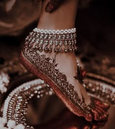 a woman's feet with jewelry on them