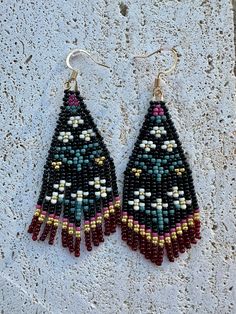 two pairs of beaded earrings on top of a white surface