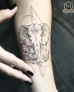 a woman's arm with an elephant and flowers tattoo on the left side of her body