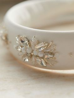 a white bracelet with flowers and pearls on it