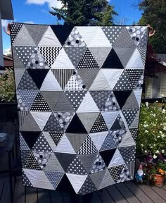 a black and white quilt sitting on top of a wooden deck