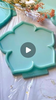 some blue plates sitting on top of a white cloth covered table with flowers in the background